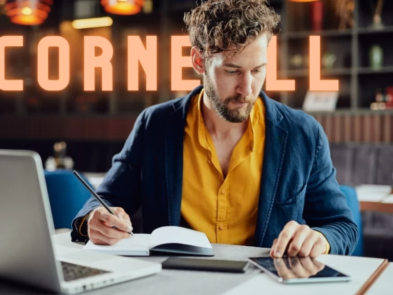 homem em uma escrivaninha tomando notas em um caderno com a palavra "Cornell" ao fundo.